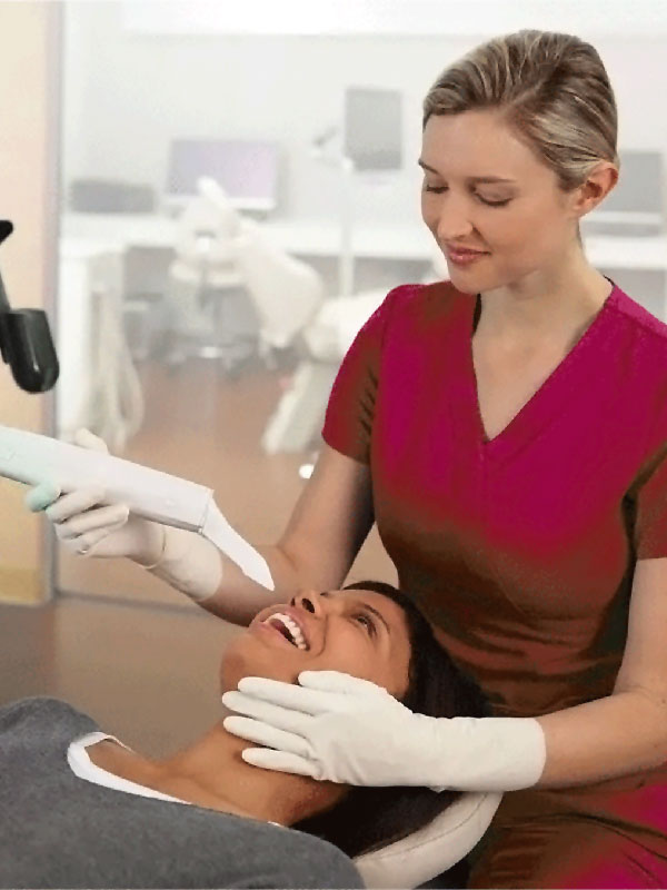 Zahnbegradigung Dental professional in gloves using a dental tool on a patient reclining in a dental chair.